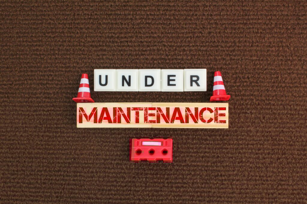 construction cones and alphabet letters with the word under maintenance